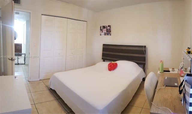 bedroom with light tile patterned floors and a closet