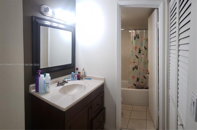 bathroom with tile patterned flooring, shower / bath combination with curtain, and vanity