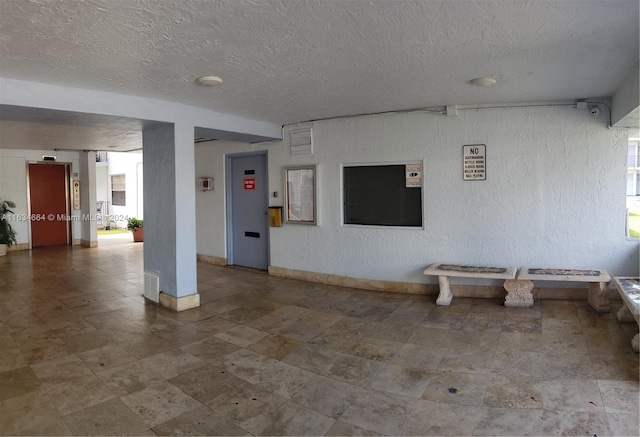 interior space featuring plenty of natural light and a textured ceiling