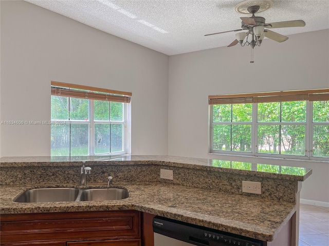 kitchen with dishwasher, stone counters, sink, and a wealth of natural light