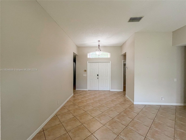 tiled entrance foyer with a textured ceiling