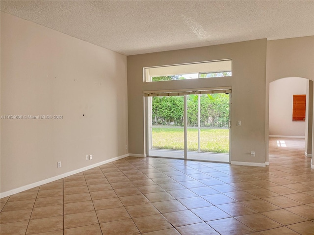 tiled spare room with a textured ceiling