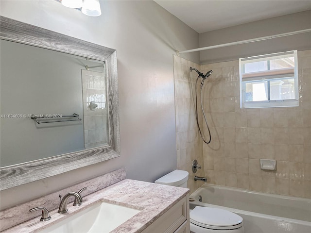 full bathroom featuring tiled shower / bath combo, toilet, and vanity