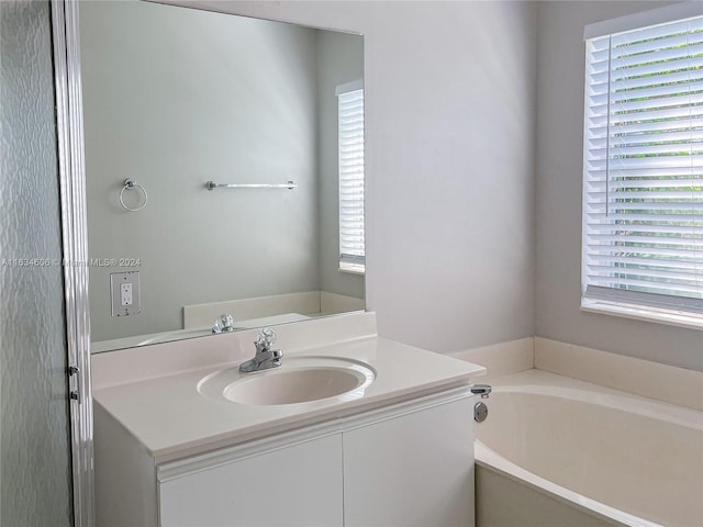 bathroom featuring a bathing tub, a wealth of natural light, and vanity