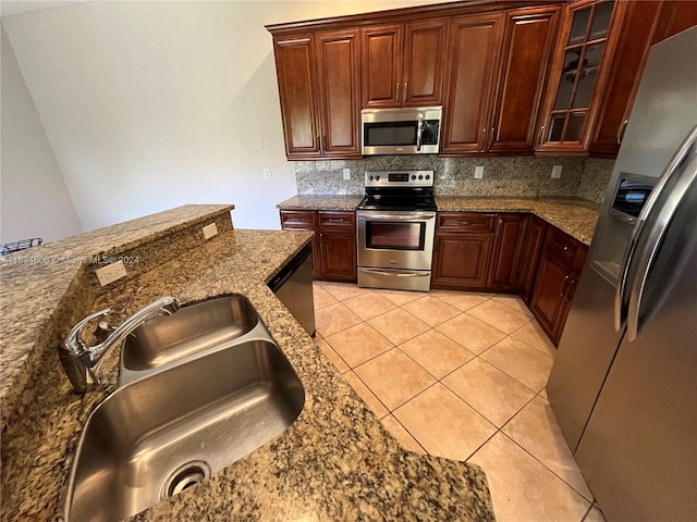 kitchen with stone counters, appliances with stainless steel finishes, decorative backsplash, and light tile patterned floors