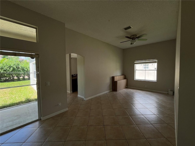 tiled empty room with a textured ceiling and ceiling fan