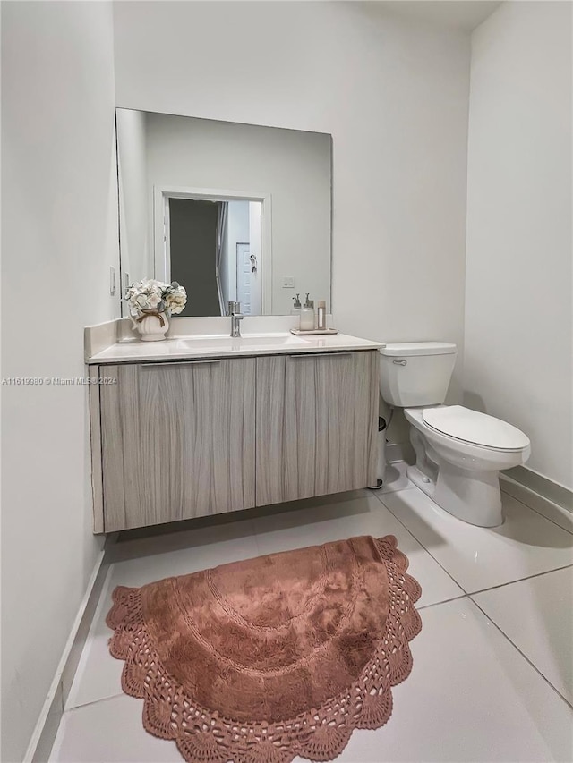 bathroom with tile patterned flooring, vanity, and toilet