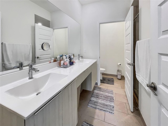 bathroom with tile patterned flooring, vanity, and toilet