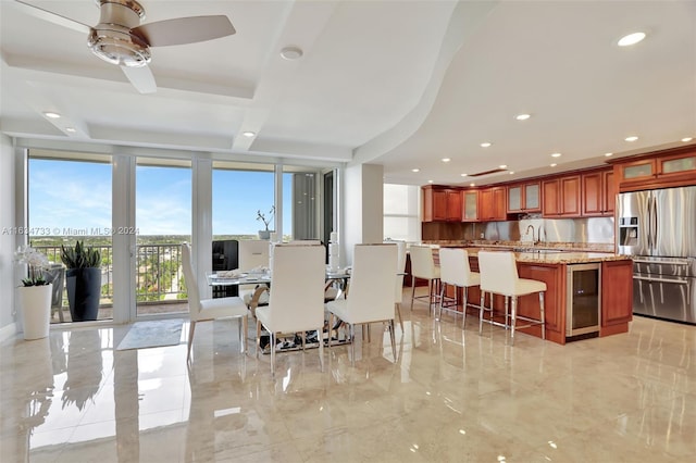 dining room with ceiling fan, sink, wine cooler, and a wall of windows