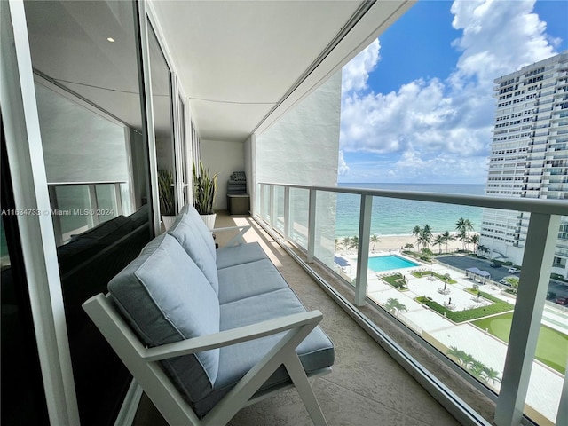 balcony featuring a view of the beach and a water view