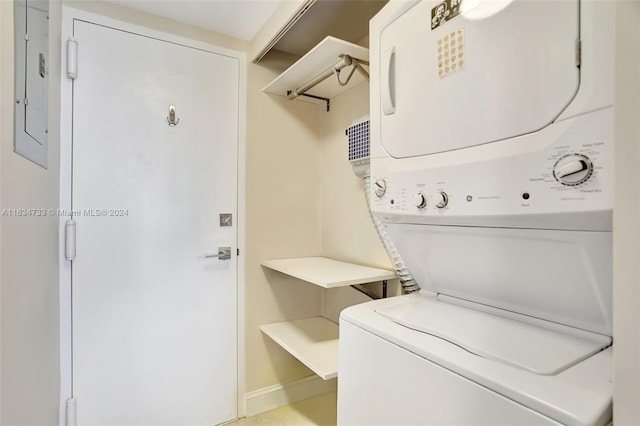 washroom featuring stacked washing maching and dryer and electric panel