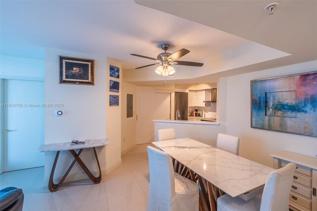 tiled dining room with electric panel and ceiling fan