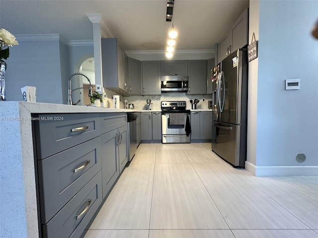 kitchen featuring stainless steel appliances, tasteful backsplash, rail lighting, and gray cabinetry