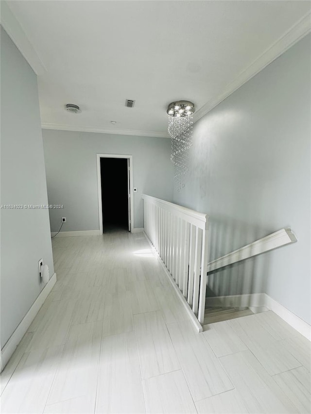 corridor featuring crown molding and a notable chandelier