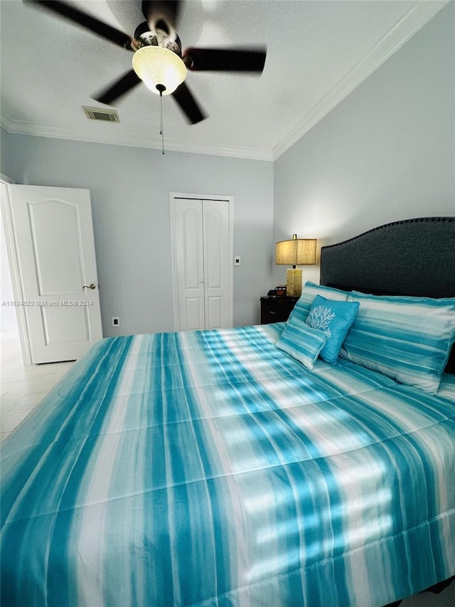 bedroom featuring crown molding, ceiling fan, and a closet