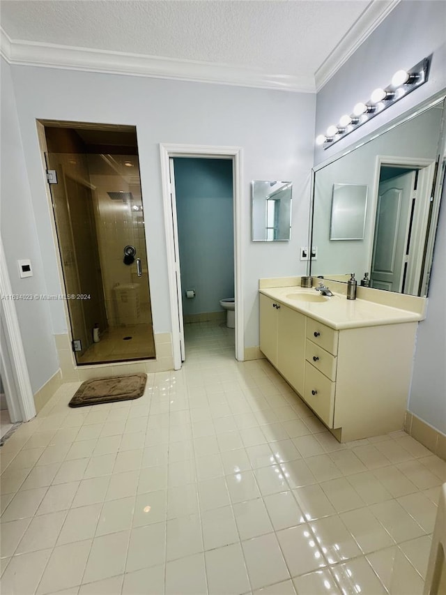 bathroom with crown molding, toilet, vanity, tile patterned floors, and a tile shower