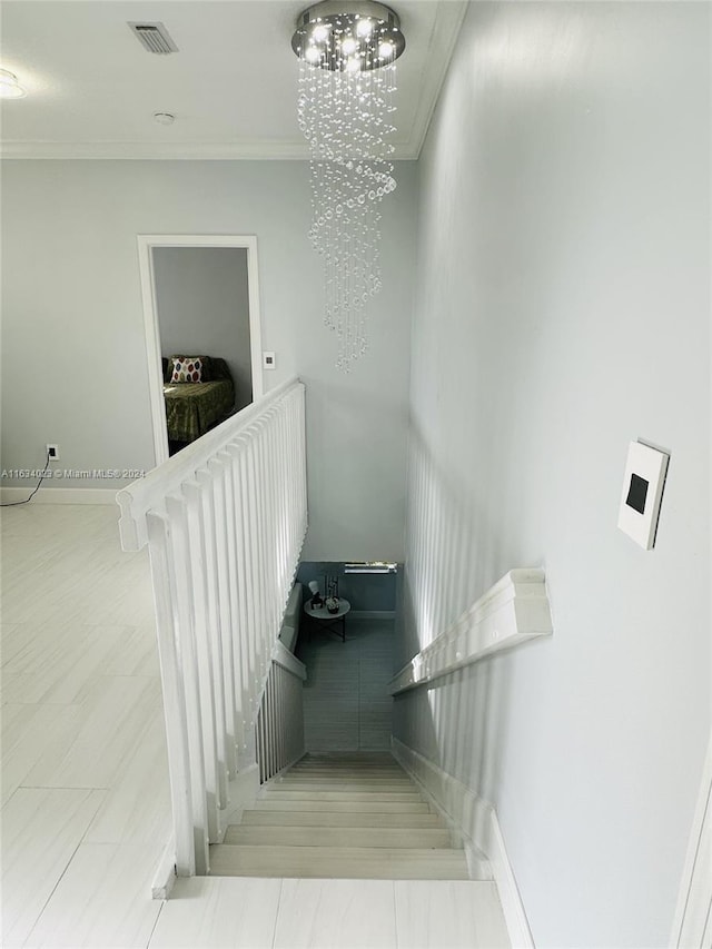 stairs with tile patterned flooring, an inviting chandelier, and ornamental molding