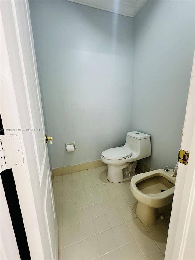 bathroom with a bidet, toilet, and tile patterned floors