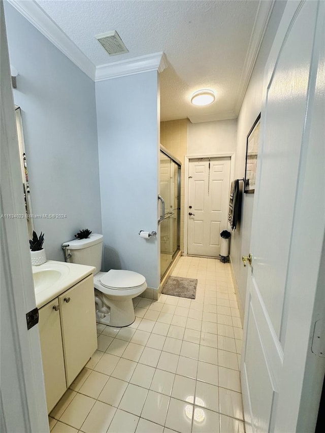 bathroom featuring tile patterned flooring, a textured ceiling, toilet, vanity, and ornamental molding