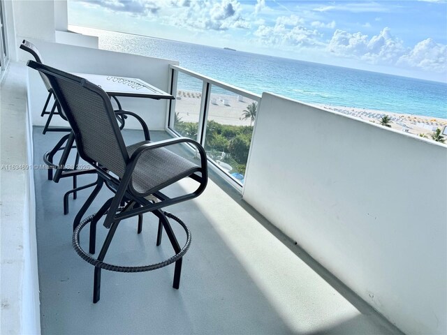 balcony featuring a beach view and a water view