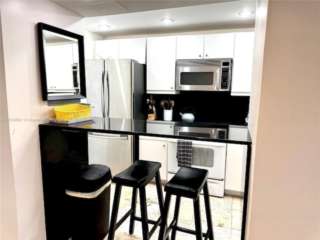 kitchen with appliances with stainless steel finishes, decorative backsplash, and white cabinets