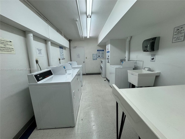 clothes washing area featuring sink and washing machine and dryer