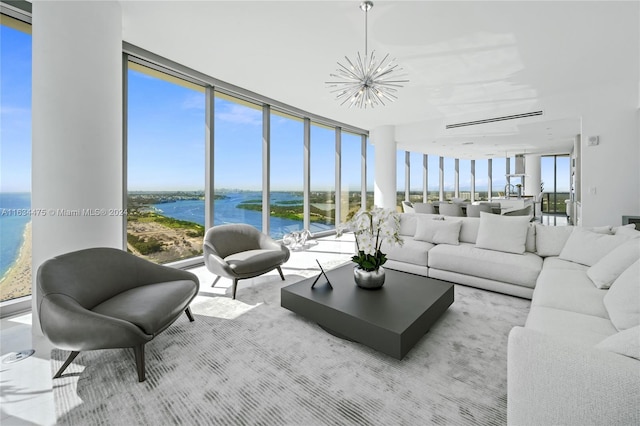 living area featuring a wall of windows, a water view, and a notable chandelier