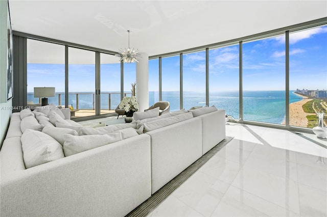 living room with a chandelier, a water view, light tile patterned floors, and floor to ceiling windows