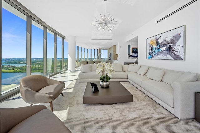 living room featuring a water view, a chandelier, and a wall of windows