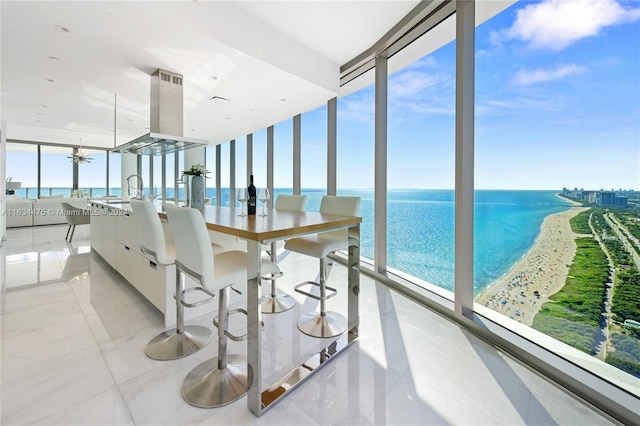 interior space featuring a water view, sink, and expansive windows