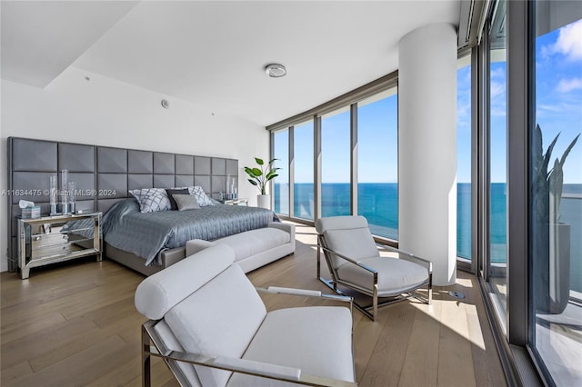 bedroom featuring a water view, dark hardwood / wood-style flooring, and floor to ceiling windows