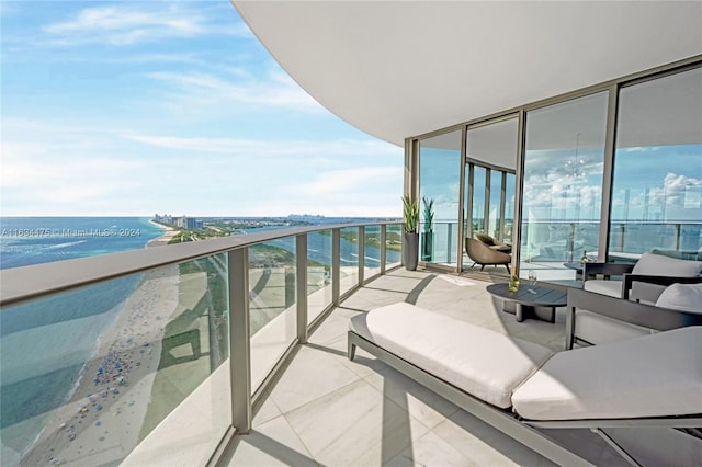 balcony with a water view and a view of the beach