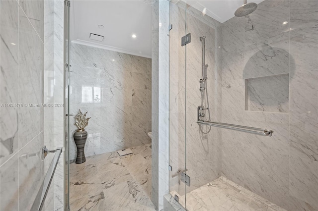 bathroom featuring tile walls, a shower with shower door, and ornamental molding