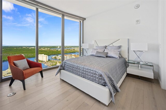 bedroom featuring floor to ceiling windows and light hardwood / wood-style floors