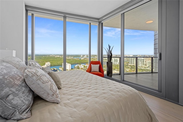 bedroom featuring floor to ceiling windows, multiple windows, and hardwood / wood-style floors