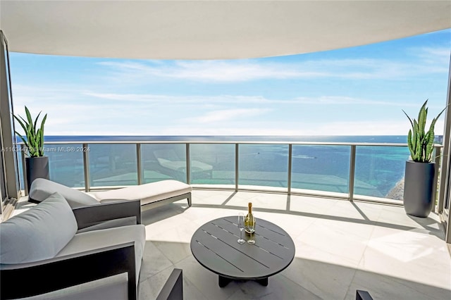 balcony with an outdoor hangout area, a beach view, and a water view