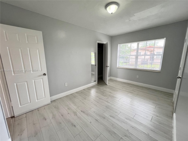 unfurnished bedroom with baseboards and wood finished floors