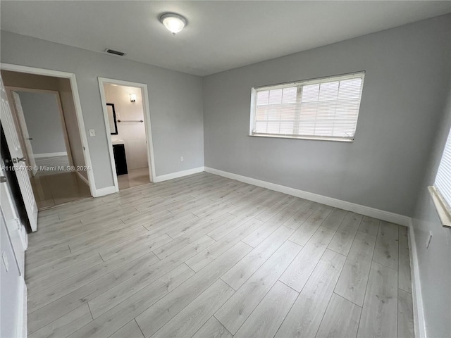 unfurnished bedroom featuring baseboards, visible vents, and light wood finished floors