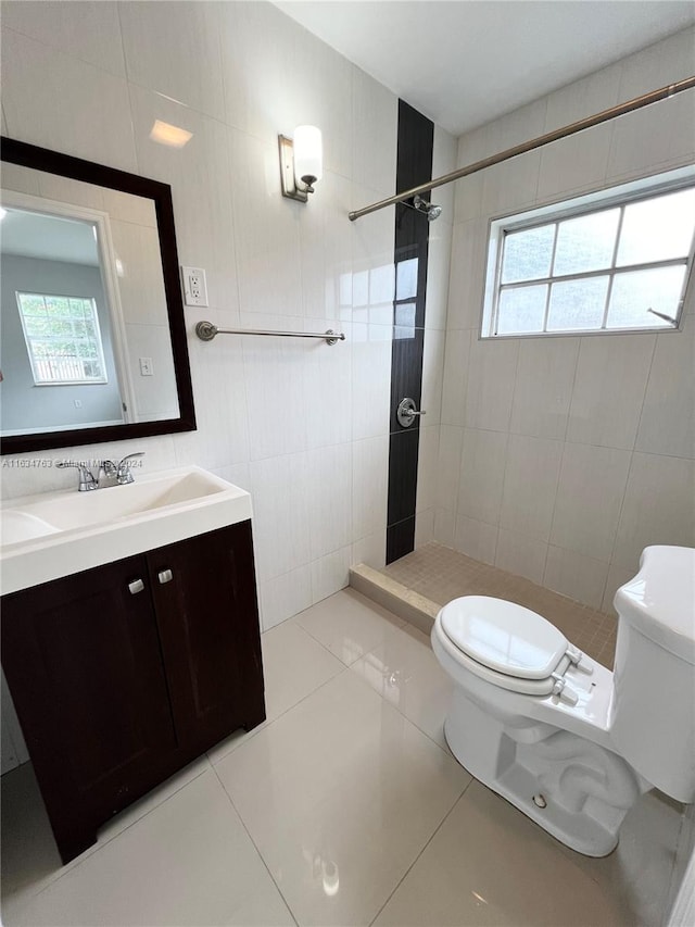 bathroom featuring tiled shower, toilet, and tile patterned floors