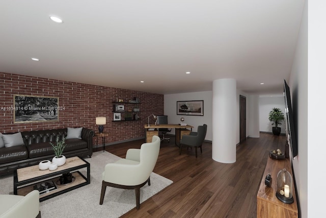 living room featuring brick wall and dark hardwood / wood-style floors