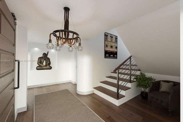 staircase featuring a barn door, hardwood / wood-style floors, and a notable chandelier