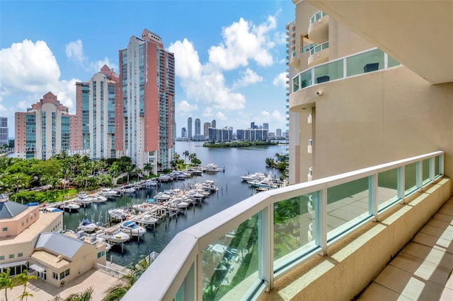 balcony with a view of skyline, view of marina, and a water view