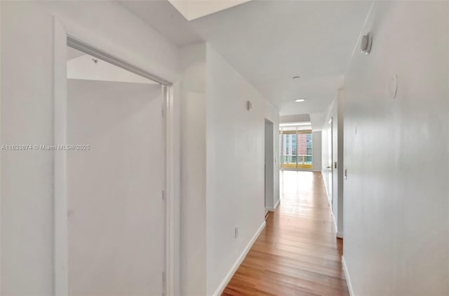 hallway with baseboards and light wood-style floors