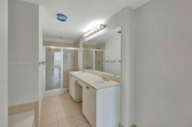 bathroom with a sink, double vanity, a shower stall, and tile patterned floors