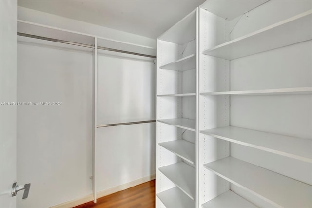 walk in closet with dark hardwood / wood-style flooring