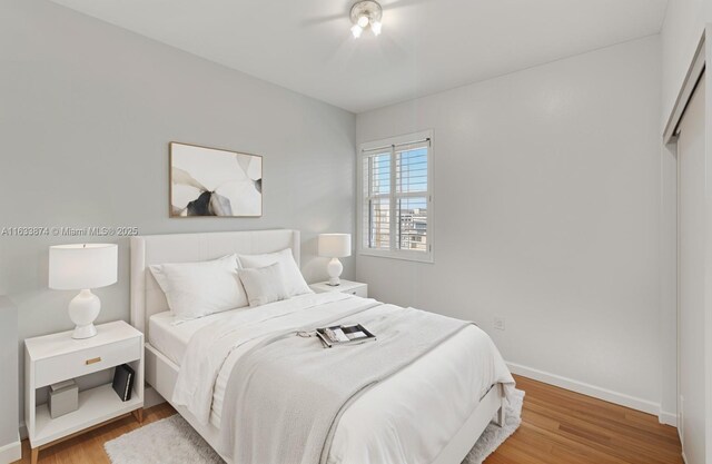 bedroom featuring wood finished floors and baseboards