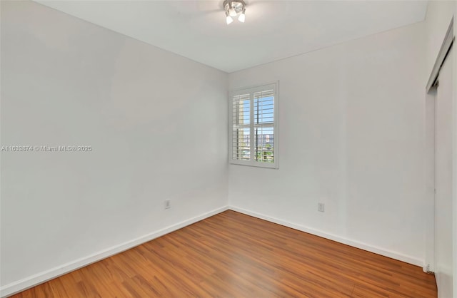 empty room with a ceiling fan, baseboards, and light wood finished floors