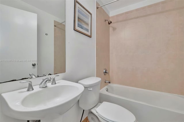 bathroom featuring toilet, shower / bathtub combination, and a sink