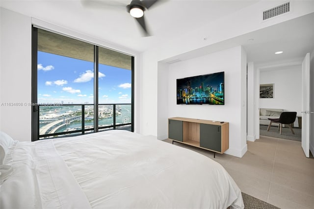 bedroom featuring light tile patterned flooring, access to exterior, expansive windows, and ceiling fan