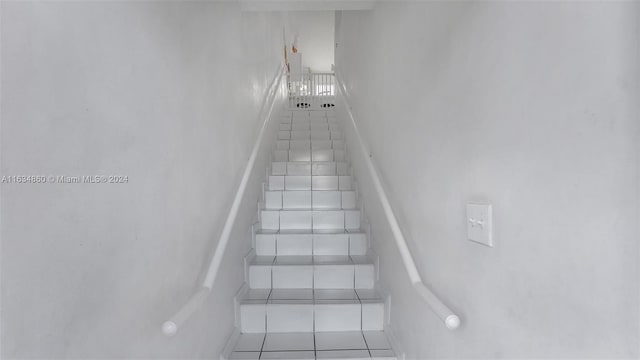 staircase featuring tile patterned flooring